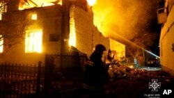 乌克兰国家紧急事务局发布照片显示，俄罗斯无人机轰炸利沃夫地区后，消防员在扑灭一座建筑物的大火。（2024年1月1日）