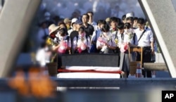 Pengunjung berdoa di depan cenotaph yang didedikasikan untuk para korban bom atom di Taman Peringatan Perdamaian Hiroshima di Hiroshima, Jepang barat, 6 Agustus 2023.