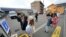 Tourists gather in front of the Lawson convenience store, a popular photo spot framing a picturesque view of Mt. Fuji in the background on cloudy evening of Tuesday, April 30, 2024, at Fujikawaguchiko town, central Japan.