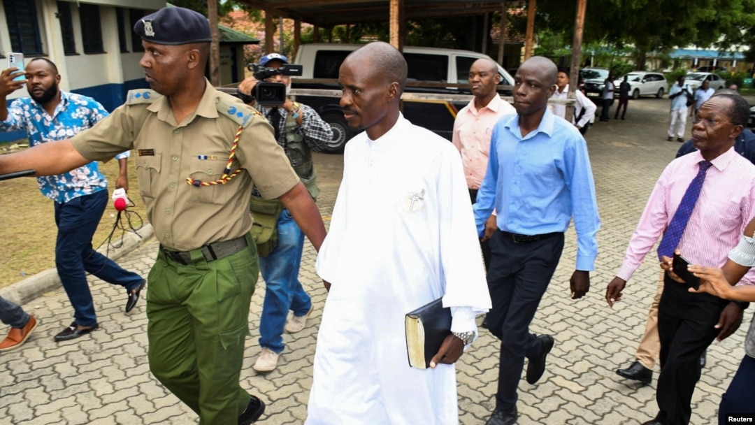 Detectives escort Ezekiel Ombok Odero, head of New Life Prayer Centre and Church in Kilifi County, at the police headquarters for investigations into deaths linked to another Christian cult, in Mombassa, Kenya, April 27, 2023.