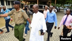 Detectives escort Ezekiel Ombok Odero, head of New Life Prayer Centre and Church in Kilifi County, at the police headquarters for investigations into deaths linked to another Christian cult, in Mombassa, Kenya, April 27, 2023.
