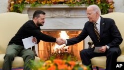 Presiden AS Joe Biden berjabat tangan dengan Presiden Ukraina Volodymyr Zelenskyy di Gedung Putih, Washington DC, Selasa (12/12). 