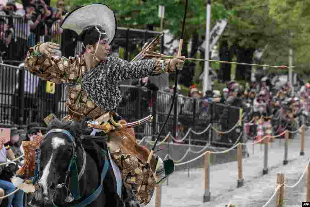 Seorang pria berseragam prajurit samurai kuno menembakkan panah ke sasaran sambil menunggang kuda selama demonstrasi seni bela diri samurai &quot;Yabusame&quot; di Taman Sumida di Tokyo, Jepang. (AFP)&nbsp;
