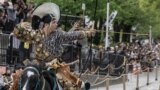 An archer in ancient samurai warrior uniform riding on a horse shoots an arrow to a target during a Yabusame horseback archery demonstration of the samurai martial arts at Sumida Park in Tokyo, April 20, 2024. 