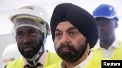 FILE - New World Bank President Ajay Banga stands with officials during his visit at the headquarters of Ivorian electricity company of Yopougon in Abidjan, Ivory Coast, March 7, 2023.