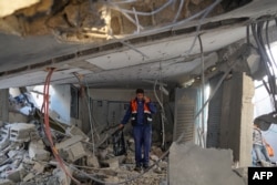 A Palestinian worker walks amid debris at a water desalination plant that was hit during a strike in Nuseirat in the central Gaza Strip, June 7, 2024.