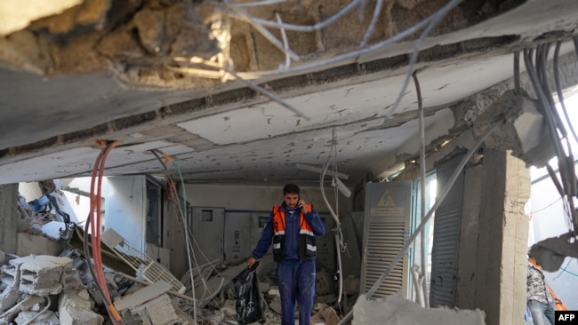 Një punonjës palestinez i ndihmave duke ecur mes rrënojave (Nuseirat, Rripi i Gazës, 7 qershor 2024)