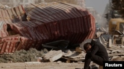 A man reacts as people search the rubble of collapsed apartment blocks for personal belongings, in the aftermath of a deadly earthquake, in Kahramanmaras, Turkey, Feb. 18, 2023.