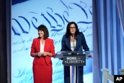 FILE - Moms for Liberty co-founders Tina Descovich, left, and Tiffany Justice, speak at the Moms for Liberty meeting in Philadelphia, Friday, June 30, 2023. (AP Photo/Matt Rourke)
