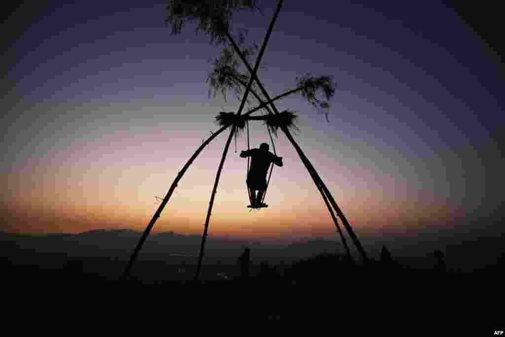 A boy sways on a swing traditionally called the &#39;Dashain Ping&#39; on the occasion of the Nepali Hindu festival &#39;Dashain&#39; near the Changu Narayan temple in Bhaktapur on the outskirts of Kathmandu.