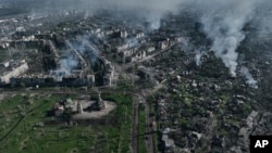 FILE - Smoke rises from buildings in this aerial view of Bakhmut, the site of the heaviest battles between Ukrainian and Russian troops in Ukraine's Donetsk, Ukraine, Apr. 26, 2023.