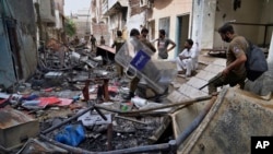 Police officers walk through the rubble of homes vandalized by an angry Muslim mob in a Christian area in Jaranwala in the Faisalabad district, Pakistan, Aug. 17, 2023. 