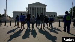 Visitors take photos in front of the U.S. Supreme Court, May 18, 2023.