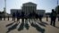 Visitors take photos in front of the U.S. Supreme Court, May 18, 2023.