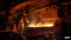 FILE - This picture taken on March 30, 2019 shows a worker manning a furnace during the nickel smelting process at Indonesian mining company PT Vale's smelting plant in Soroako, South Sulawesi, Indonesia.