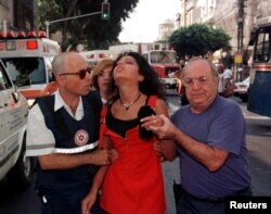 Radnici hitne pomoći pomažu Izraelki posle bombaškog napada u Tel Avivu u avgustu 1998 (Foto: Reuters)