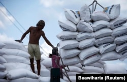 Seorang buruh berdiri di dekat karung pupuk di Pelabuhan Sunda Kelapa, Jakarta, 22 Maret 2010. (Foto: REUTERS/Beawiharta)