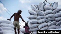 Seorang buruh berdiri di dekat karung-karung pupuk di Pelabuhan Sunda Kelapa, Jakarta. (Foto: REUTERS/Beawiharta)