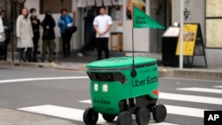 Robot pengantar makanan Uber Eats menyeberang jalan saat demonstrasi untuk media di Tokyo, Jepang, Selasa, 5 Maret 2024. Uber Eats Jepang berencana meluncurkan layanan pengiriman robot di sebuah kawasan di Tokyo, Rabu, 6 Mei 2024. (AP/Shuji Kajiyama)