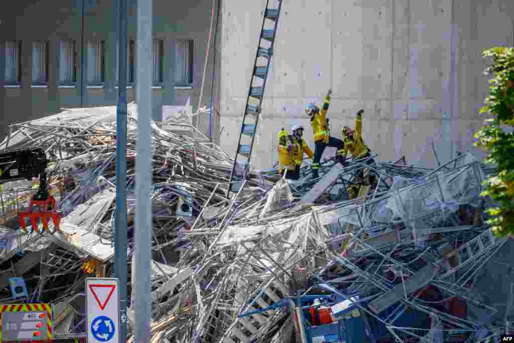 Petugas pemadam kebakaran bekerja di lokasi kecelakaan perancah yang runtuh di pinggiran kota Malley, Lausanne, Swiss. (AFP)&nbsp;