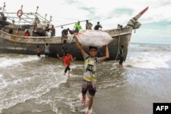 Sekitar 50 orang dewasa dan anak-anak Rohingya terdampar di pantai Lampanah, Aceh Besar, 16 Februari 2023. (AFP)