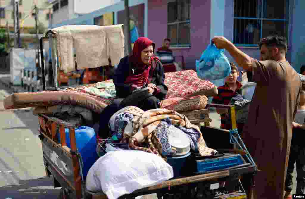 Palestinians who fled their homes amid Israeli strikes, arrive with their belongings to shelter in a United Nations-run school in Gaza City, Oct. 8, 2023. 