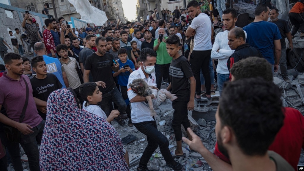 Một đứa trẻ được đưa ra khỏi đống đổ nát của một tòa nhà sau cuộc không kích ở Khan Younis, Dải Gaza, ngày 21 tháng 10 năm 2023.