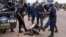 Security forces assault a supporter of presidential candidate Martin Fayulu during clashes outside his party's headquarters, in Kinshasa, Democratic Republic of the Congo.