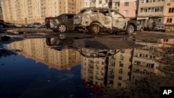 Destroyed cars are reflected in a pool of water after a Russian airstrike on residential neighborhood in Sumy, Ukraine, on Aug. 17, 2024. 