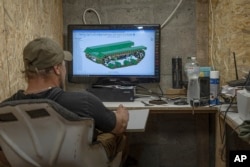 Serhii, chief engineer of design and production bureau "UkrPrototyp", works on 3D model of a a car-sized 800-kilogram (1,750-pound) prototype drone, in the north of Ukraine, Thursday, June 27, 2024. (AP Photo/Anton Shtuka)