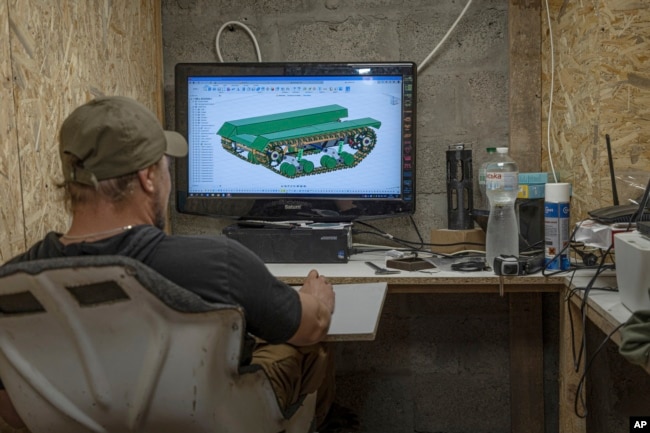 Serhii, chief engineer of design and production bureau "UkrPrototyp", works on 3D model of a a car-sized 800-kilogram (1,750-pound) prototype drone, in the north of Ukraine, Thursday, June 27, 2024. (AP Photo/Anton Shtuka)