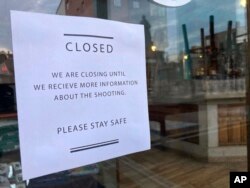 A sign in the door of Eventide Oyster Co. on Oct. 27, 2023, advises clients that the seafood restaurant in Portland, Maine, will be closed as staff await information about the deadly shooting in Lewiston.