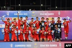 Indonesia's team celebrates on the podium after winning the men's football final match against Thailand during the 32nd Southeast Asian Games (SEA Games) in Phnom Penh on May 16, 2023.