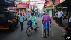 FILE - An elderly man walks through a street in the historic ward of Mattancherry, in Kochi, Kerala state, India, March 6, 2023. 