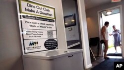 A donation box for the Meals on Wheels "Dine Out Club" is posted at the White Birch Cafe in Goffstown, New Hampshire, Aug. 16, 2023.