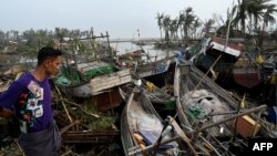 A local resident looks at broken boats in Sittwe, in Myanmar's Rakhine state, on May 15, 2023, after cyclone Mocha made a landfall.