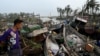 A local resident looks at broken boats in Sittwe, in Myanmar's Rakhine state, on May 15, 2023, after cyclone Mocha made a landfall.