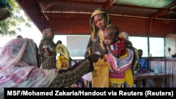 FILE - A handout photograph, shot in January 2024, shows a woman and baby at the Zamzam displacement camp, close to El Fasher in North Darfur, Sudan. (MSF/Mohamed Zakaria/Handout via Reuters)