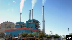 FILE - Gas emissions rise from a coal power plant in Colstrip, Montana, July 1, 2013. Youth plaintiffs are challenging the constitutionality of a Montana policy that does not require state agencies to consider how fossil fuels affects residents' lives. 