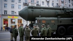 FILE - Soldiers stand next to a Russian RS-24 Yars ballistic missile parked along Tverskaya street prior to a rehearsal for the Victory Day military parade in Moscow, May 2, 2024.