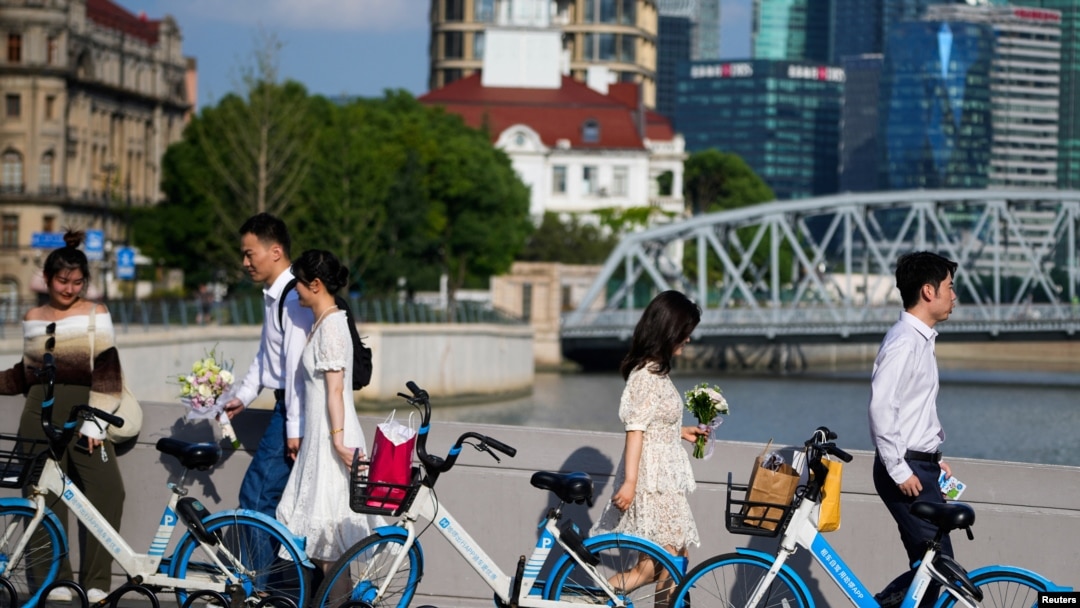 FILE - Couples prepare to get their photo taken during a wedding photography shoot on a street, in Shanghai, China Sept. 6, 2023.