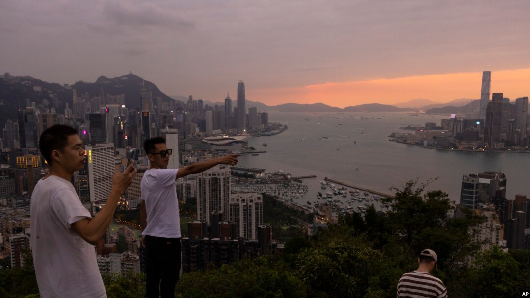中国大陆游客在山顶拍摄香港夕照景色。(2023年4月26日)
