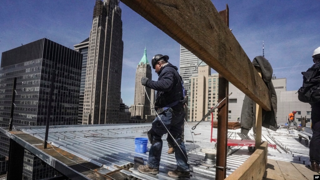 资料照片：2023年4月11日，建筑工人在纽约曼哈顿金融区的一座高层建筑上安装屋顶。（美联社照片）(photo:VOA)