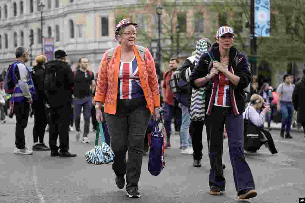 Royal fans walk towards the Mall to find a place where they can watch the procession of the coronation of Britain's King Charles III in London, May 6, 2023. 