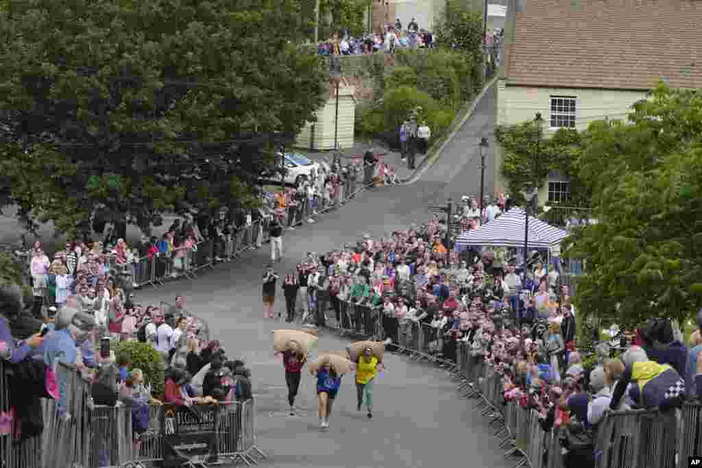 Participants race with Woolsack on their shoulders during the annual Tetbury Woolsack Races in Tetbury, Gloucestershire, England.