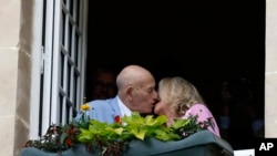 FILE - US WWII veteran Harold Terens, 100, left, and Jeanne Swerlin, 96, kiss from a window after celebrating their wedding at the town hall of Carentan-les-Marais, in Normandy, France, June 8, 2024. (AP Photo/Jeremias Gonzalez)