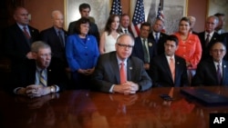 FILE - House Speaker Paul Ryan of Wisconsin, with House Veterans' Affairs Committee Chairman Rep. Phil Roe, Senate Veterans' Affairs Chairman Sen. Johnny Isakson, and other committee members, listen to Rep. Tim Walz, on Capitol Hill, June 21, 2017.