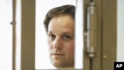 FILE - Wall Street Journal reporter Evan Gershkovich stands in a glass cage in a courtroom at the Moscow City Court in Moscow, Russia, June 22, 2023.