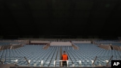 FILE - A steward stands amidst empty seats at Arena Khimki stadium in Moscow, Russia, Sept. 30, 2014. Moscow on Tuesday postponed the World Friendship Games which had been due to take place in Russia in September.