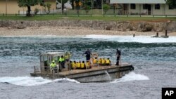 Sekelompok pencari suaka asal Vietnam dibawa dengan tongkang ke dermaga di Pulau Christmas Australia pada 14 April 2013. (Foto: AP)